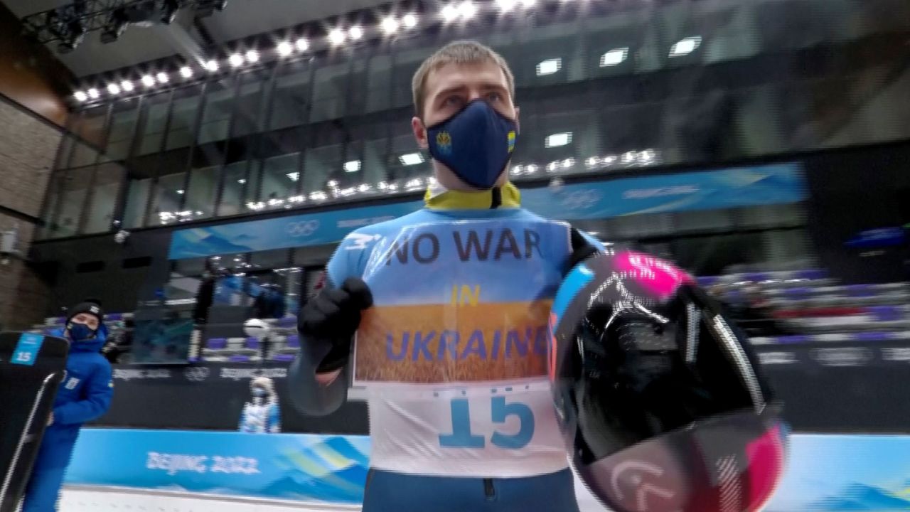 Heraskevych holds a sign with a message reading "No war in Ukraine."