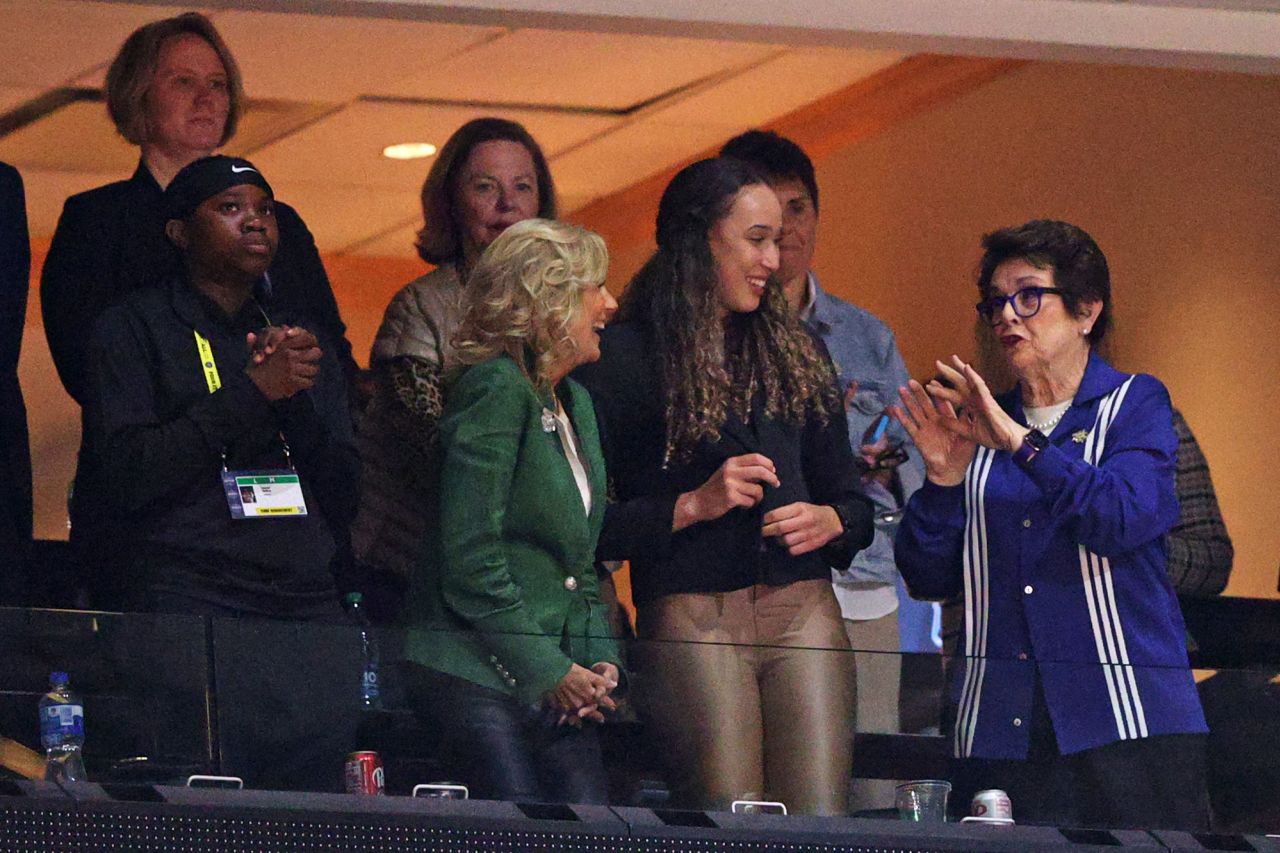 First lady Jill Biden, in the green jacket, takes in the game with tennis legend Billie Jean King, right.