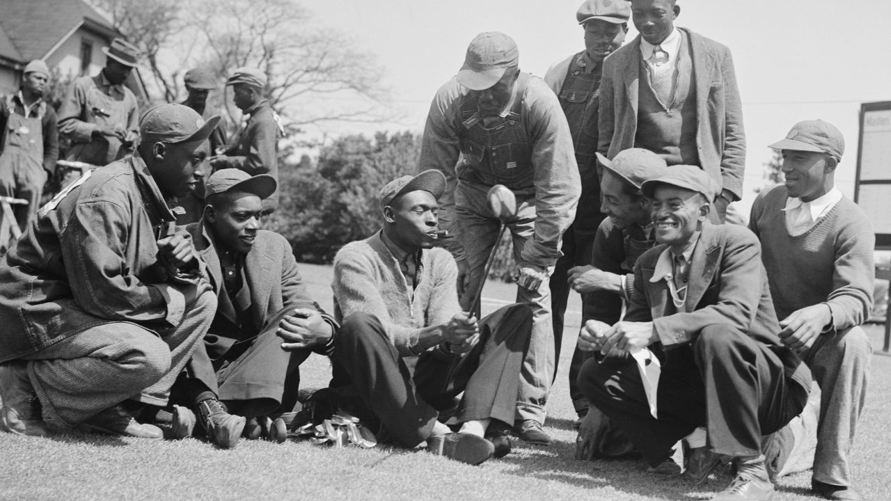 John H. "Stovepipe" Gordon (center), caddie for Gene Sarazen, shows fellow caddies the club Sarazen made a double eagle with at the 1935 Masters.