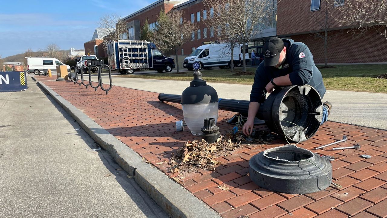 A street light is repaired at UConn after fans spilled onto campus to celebrate.