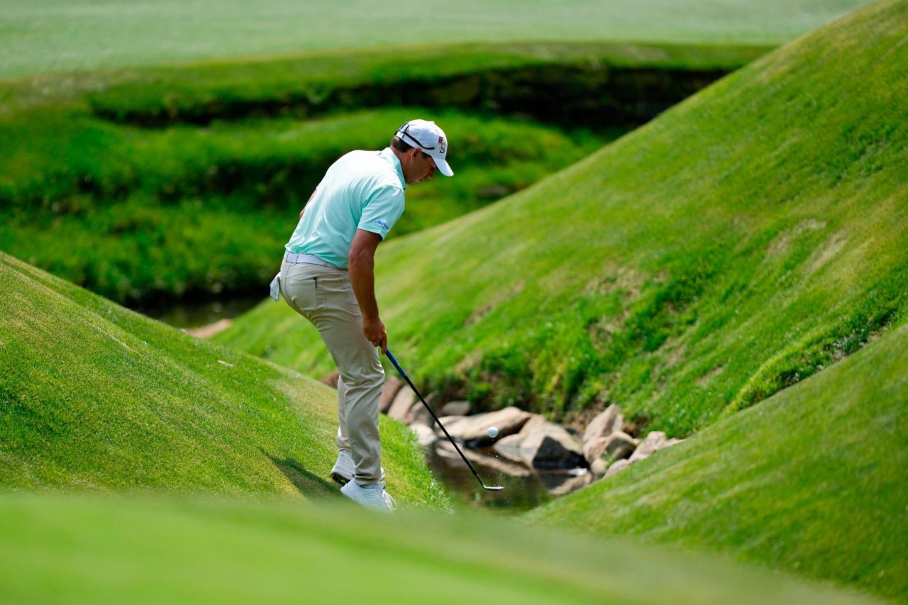 Sergio Garcia fishes his ball out of the creek on No. 13.