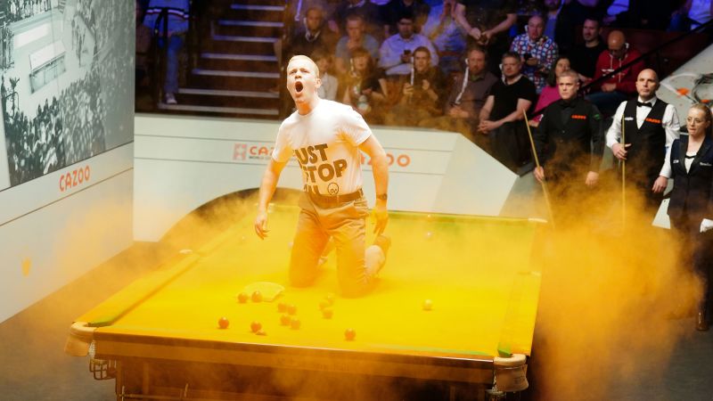 Just Stop Oil protester disrupts World Snooker Championship by throwing orange powder paint on table