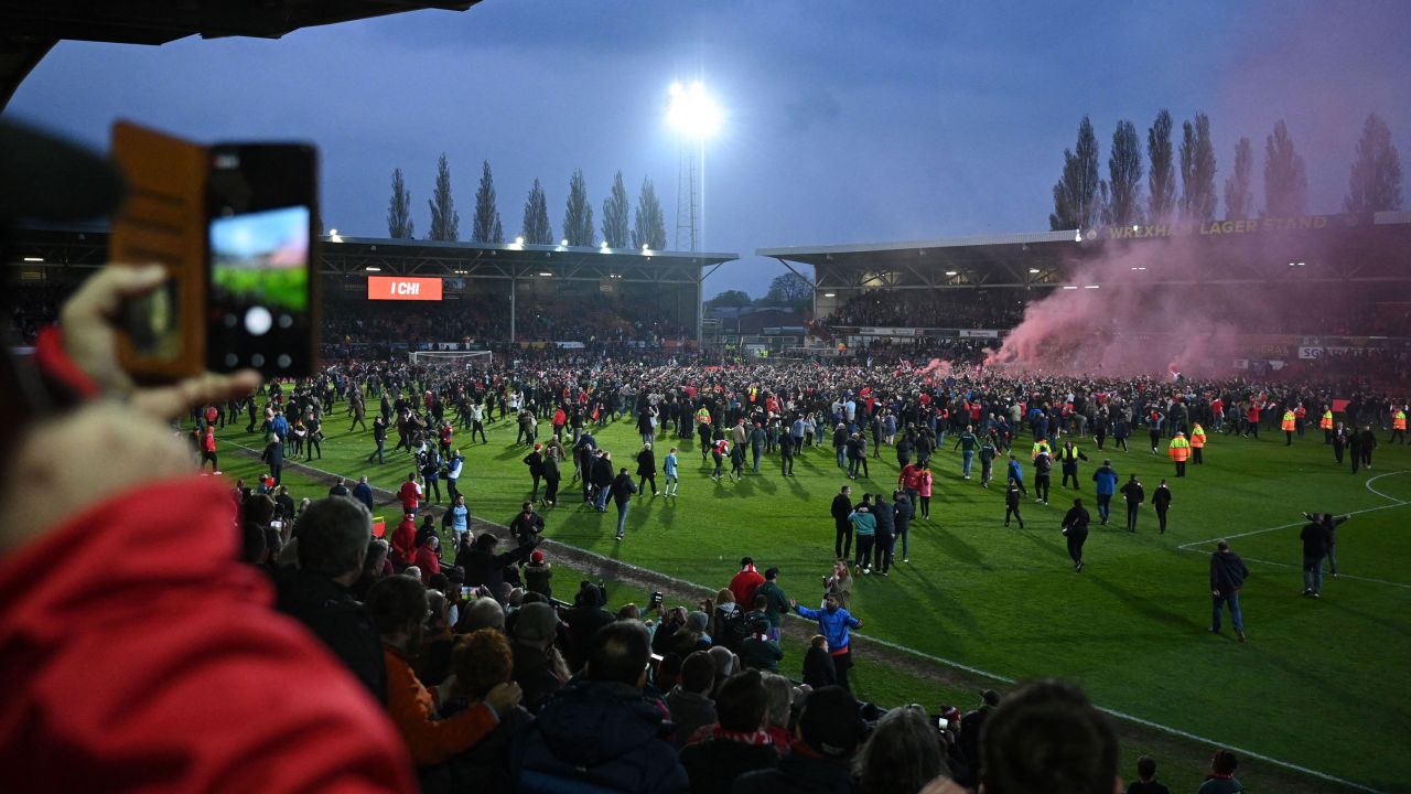 Wrexham's fans celebrate on the pitch after the club won the title.