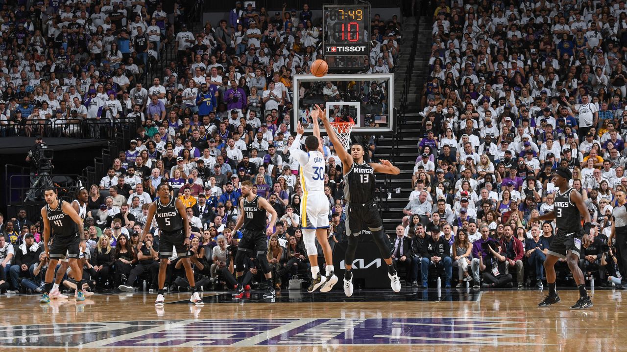 Curry shoots a three-point basket during the game against the Kings.