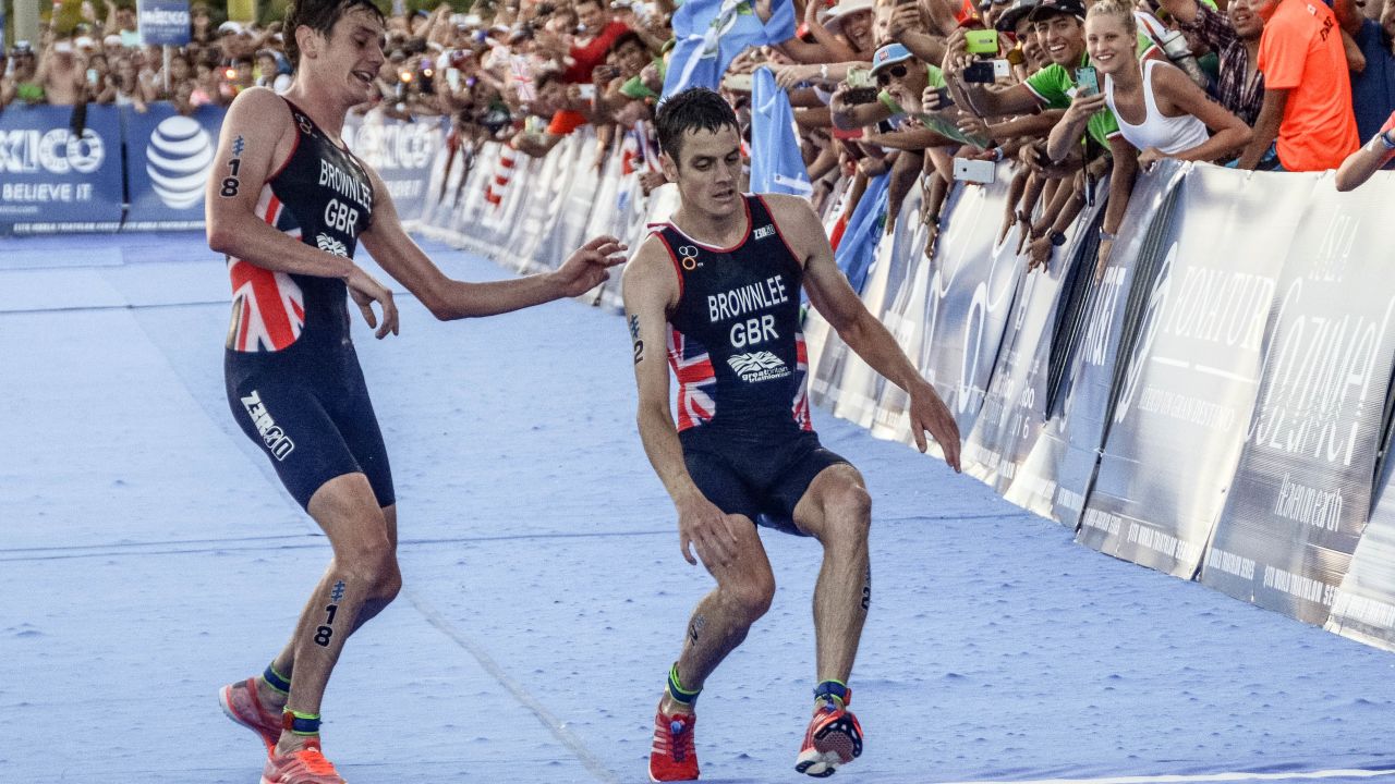 Alistair Brownlee (L) helps his brother Jonny (R) cross the line during the 2016 ITU World Triathlon Championships.