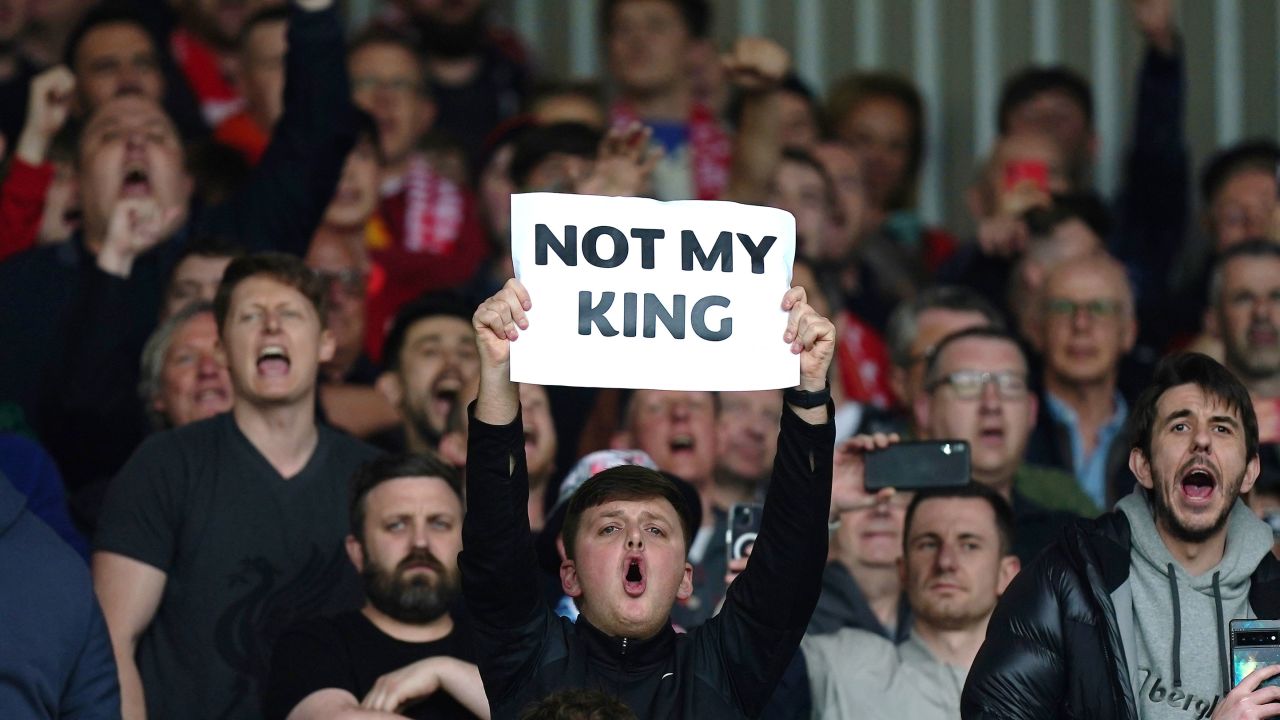 A Liverpool fan holds up a sign saying 'Not My King.'