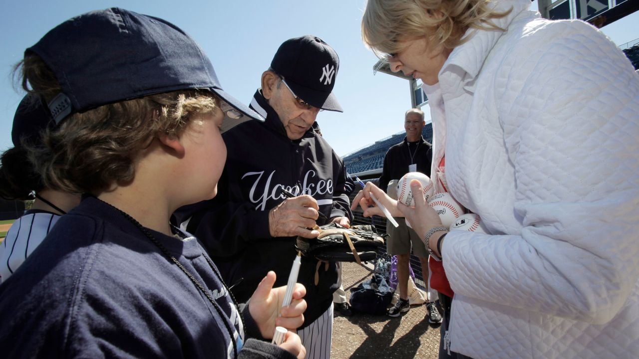 New York Yankees Hall of Fame catcher Yogi Berra signs autographs for special guests of the Yankees before team's spring training baseball game against the Toronto Blue Jays at Steinbrenner Field in Tampa, Fla., in March 2010.