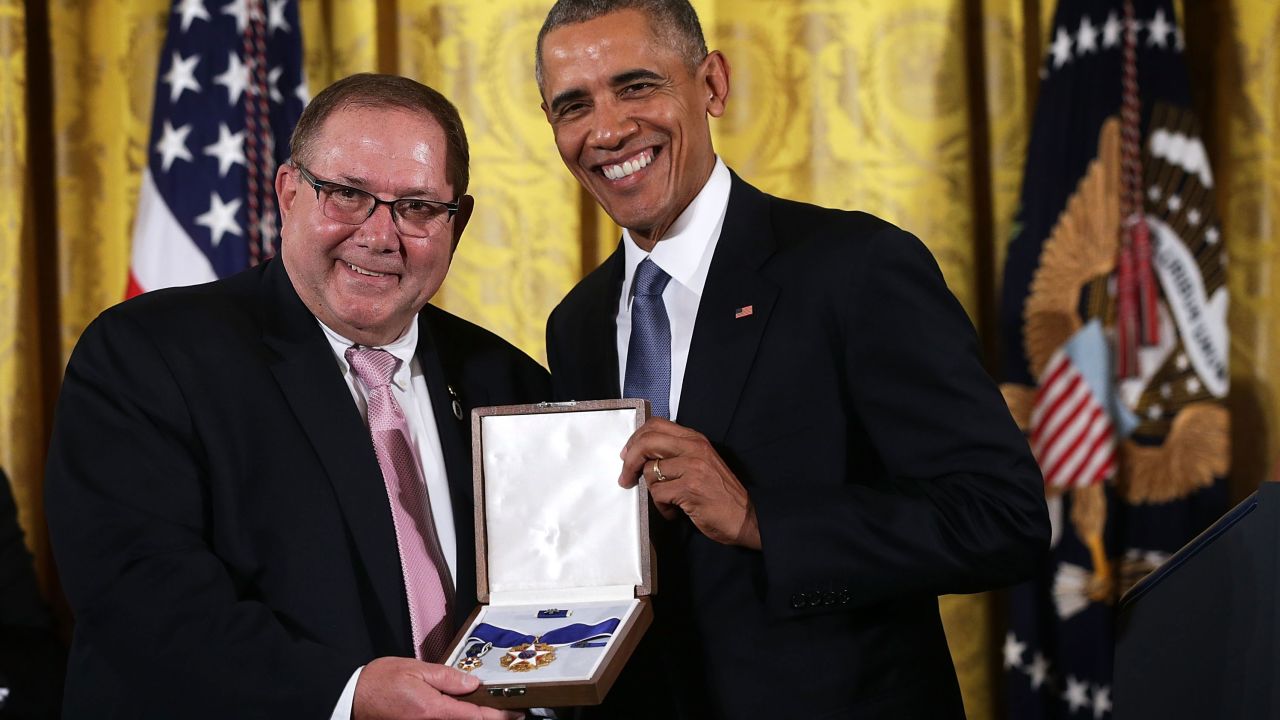 Larry Berra (L), son of baseball legend Yogi Berra, receives the Presidential Medal of Freedom on behalf of his father from US President Barack Obama (R) during an East Room ceremony November 24, 2015 at the White House in Washington, DC.