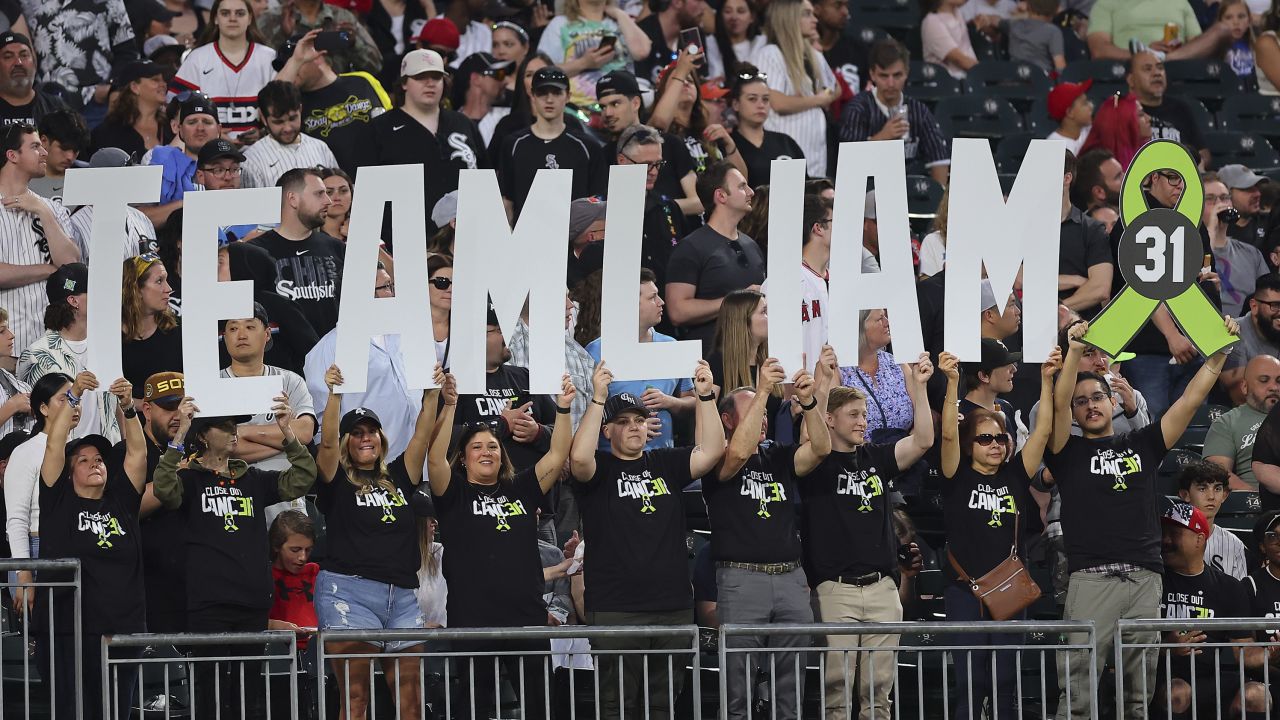 Fans hold a sign honoring Hendriks's return.