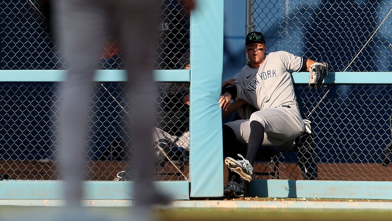 Judge crashes through the outfield fence as he makes a catch against the Dodgers.