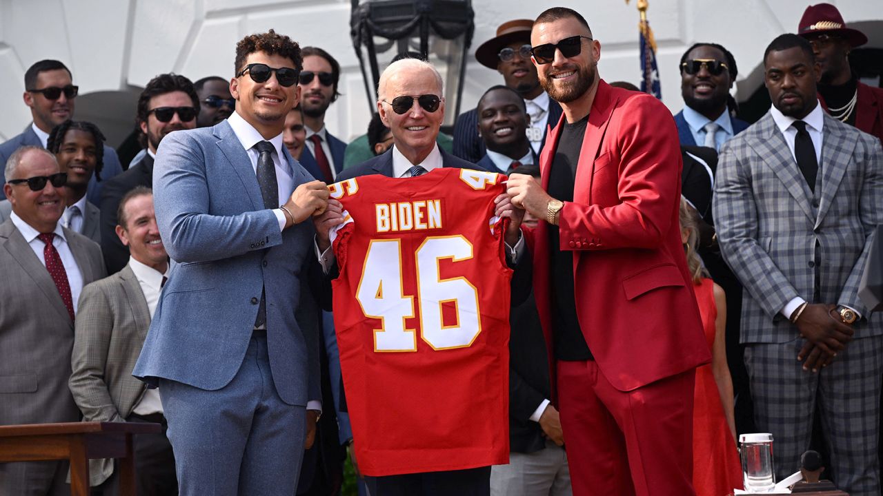 Mahomes and Kelce present President Biden with a Chiefs jersey.