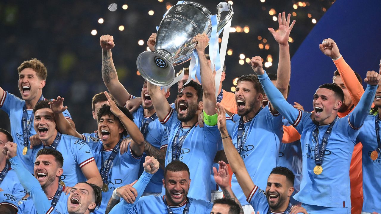 TOPSHOT - Manchester City's German midfielder #8 Ilkay Gundogan (C) lifts the European Cup trophy as they celebrate on the podium after winning the UEFA Champions League final football match between Inter Milan and Manchester City at the Ataturk Olympic Stadium in Istanbul, on June 10, 2023. (Photo by FRANCK FIFE / AFP) (Photo by FRANCK FIFE/AFP via Getty Images)