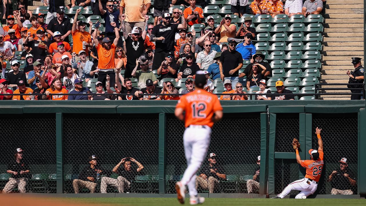 BALTIMORE, MD - JUNE 10: Fans react as Anthony Santander #25 of the Baltimore Orioles makes a catch as he crashes with the wall in the first inning against the Kansas City Royals at Oriole Park at Camden Yards on June 10, 2023 in Baltimore, Maryland.