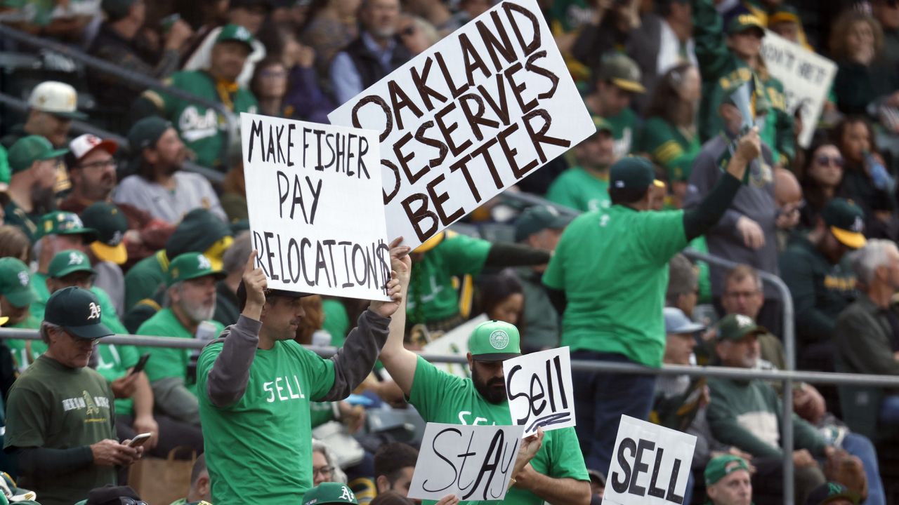 Fans hold signs inside of the Oakland Coliseum to protest the Oakland Athletics' planned move to Las Vegas during a baseball game between the Athletics and the Tampa Bay Rays in Oakland, Calif., Tuesday, June 13, 2023. (AP Photo/Jed Jacobsohn)