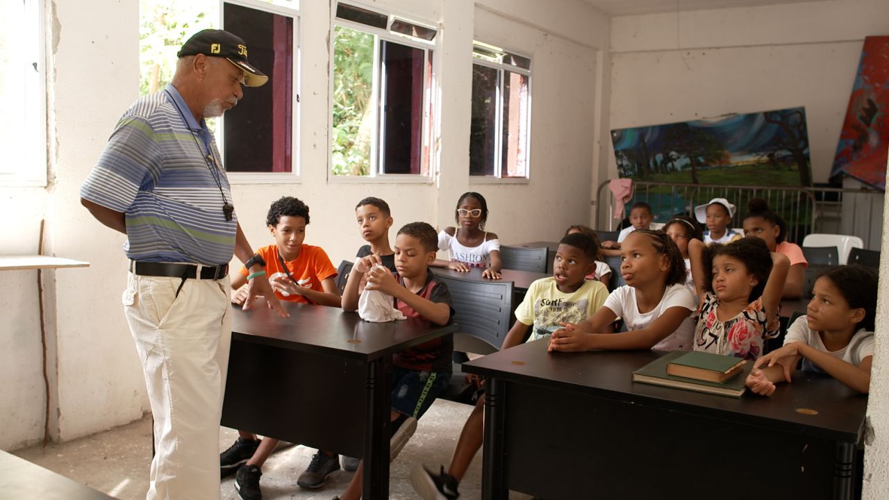 Tiago Albuquerque teaches English to children from Modesto’s golf academy.