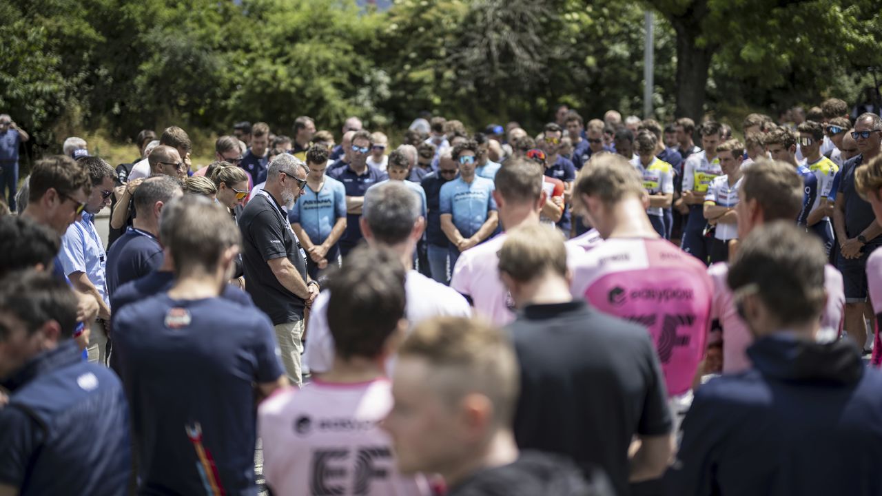 Event director Olivier Senn, center left, holds a minute of silence in honour of Gino Maeder from Switzerland of Bahrain-Victorious, who died following his crash the day before, at the 86th Tour de Suisse UCI World Tour cycling race, in Chur, Switzerland, Friday, June 16, 2023. (Gian Ehrenzelle/Keystone via AP)