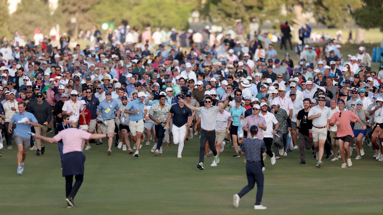 Crowds spill onto the 18th fairway to watch the closing stages.