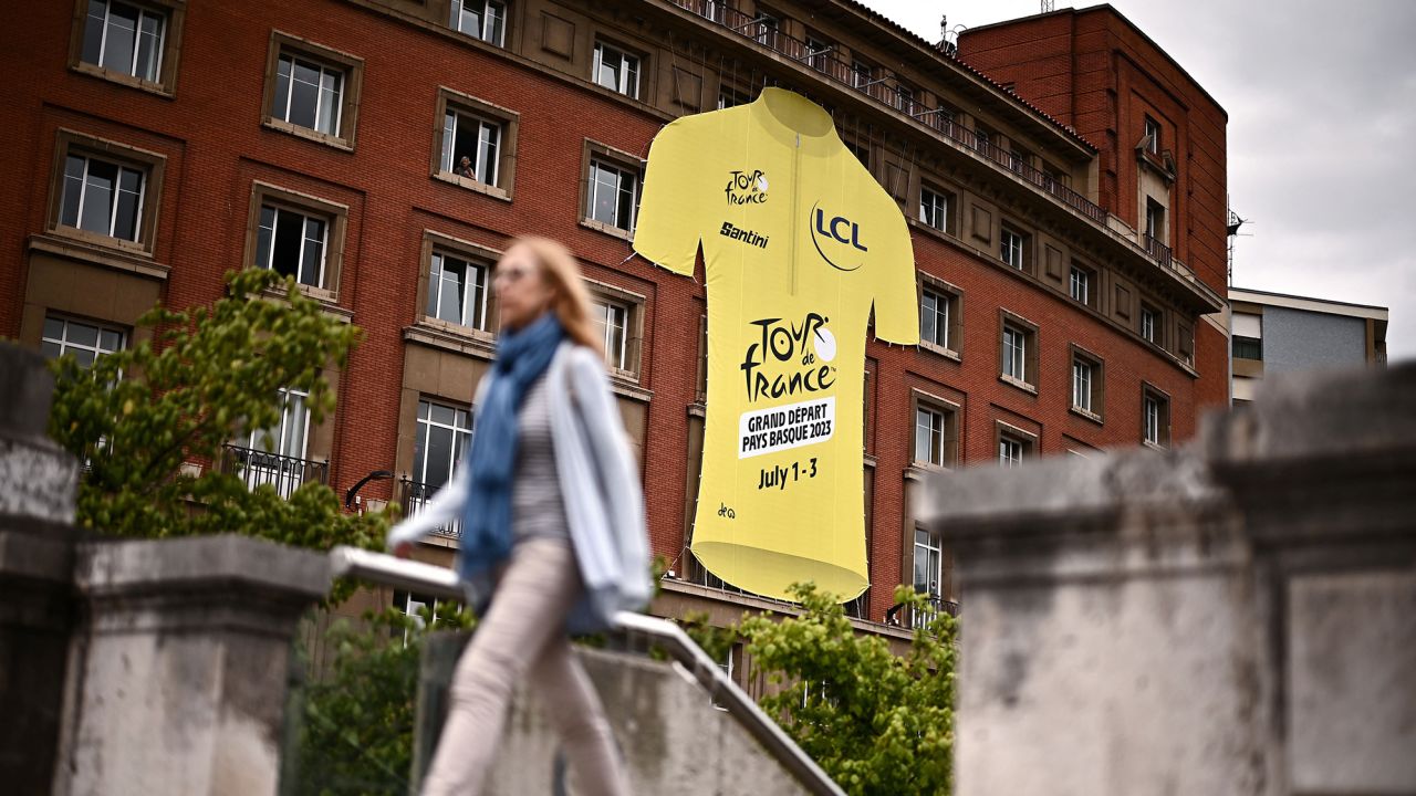 A pedestrian walks past a giant yellow jersey ahead of the 110th edition of the Tour de France cycling race, in Bilbao, on July 27, 2023. The Tour de France will start in Bilbao, on July 1, 2023. (Photo by Marco BERTORELLO / AFP) (Photo by MARCO BERTORELLO/AFP via Getty Images)