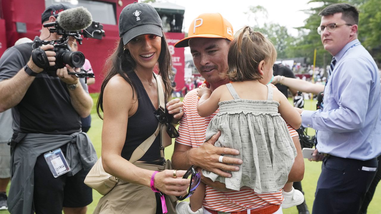 Rickie Fowler walks off the 18th green with his wife Allison Stokke and daughter after the final round of the Rocket Mortgage Classic golf tournament at Detroit Country Club, Sunday, July 2, 2023, in Detroit. (AP Photo/Carlos Osorio)