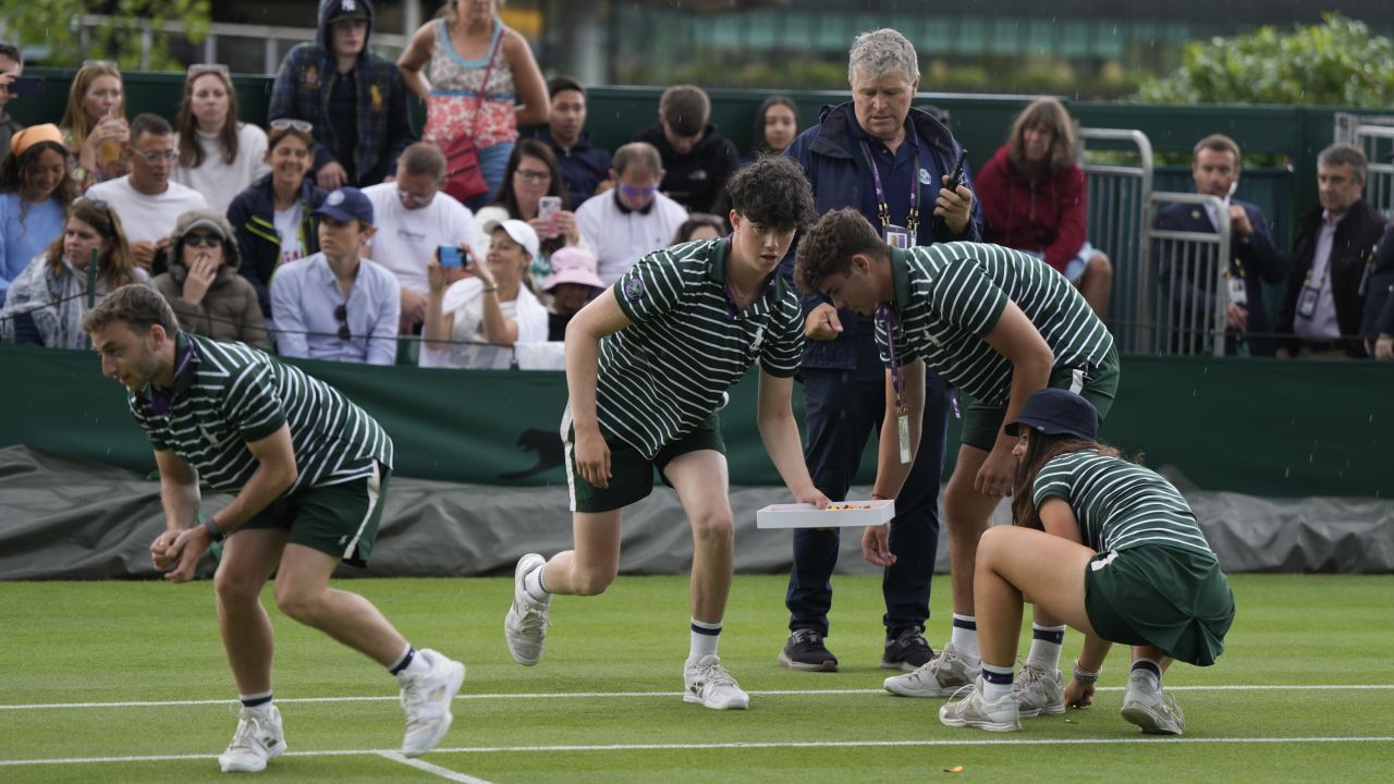 Ground staff remove pieces of confetti from Court 18 after being released by a Just Stop Oil protester on day three of the Wimbledon tennis championships in London, Wednesday, July 5, 2023. (AP Photo/Alastair Grant)