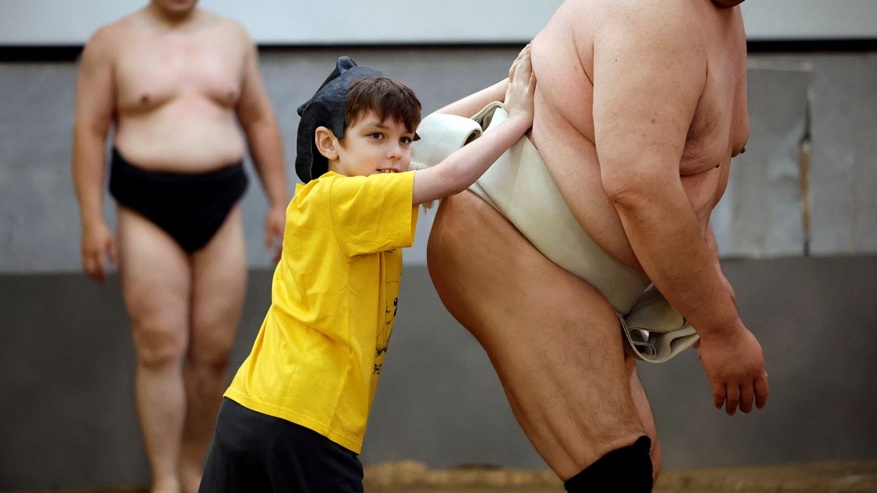 Theo, a 9-year-old child from Australia, tries to spar against former sumo wrestler Towanoyama on the sumo ring before tourists from abroad, at Yokozuna Tonkatsu Dosukoi Tanaka in Tokyo, Japan June 30, 2023.   REUTERS/Issei Kato