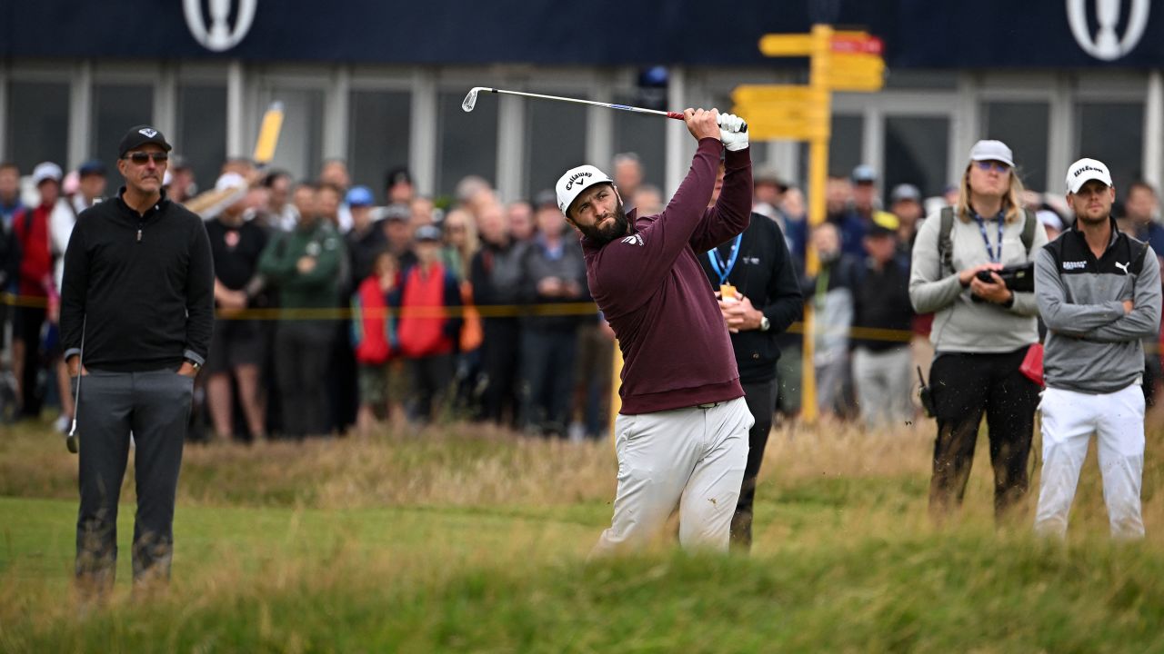 US golfer Phil Mickelson (L) watches as Spain's Jon Rahm (C) plays a shot from the 2nd fairway during a practice round for 151st British Open Golf Championship at Royal Liverpool Golf Course in Hoylake, north west England on July 19, 2023. The Royal Liverpool Golf Course will host The 151st Open from July 20 to 23, 2023. (Photo by Paul ELLIS / AFP) / EDITORIAL USE ONLY (Photo by PAUL ELLIS/AFP via Getty Images)