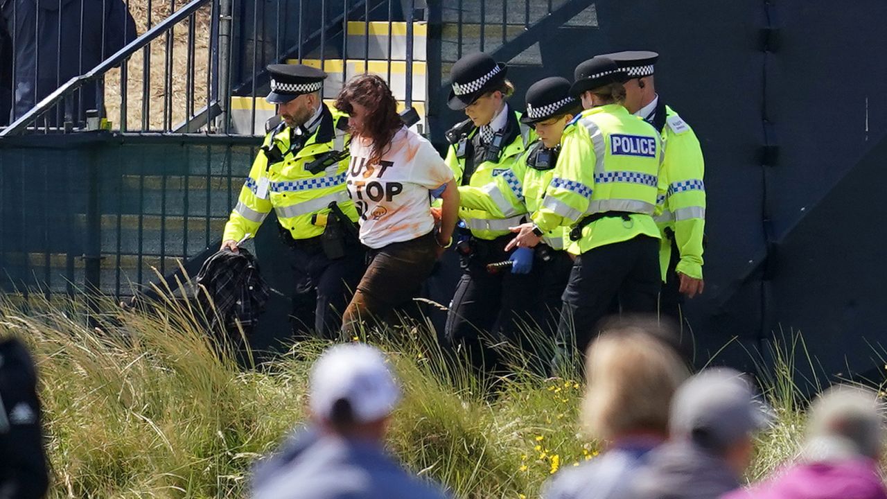 A Just Stop Oil protester is taken away by Police during day two of The Open at Royal Liverpool, Wirral. Picture date: Friday July 21, 2023.