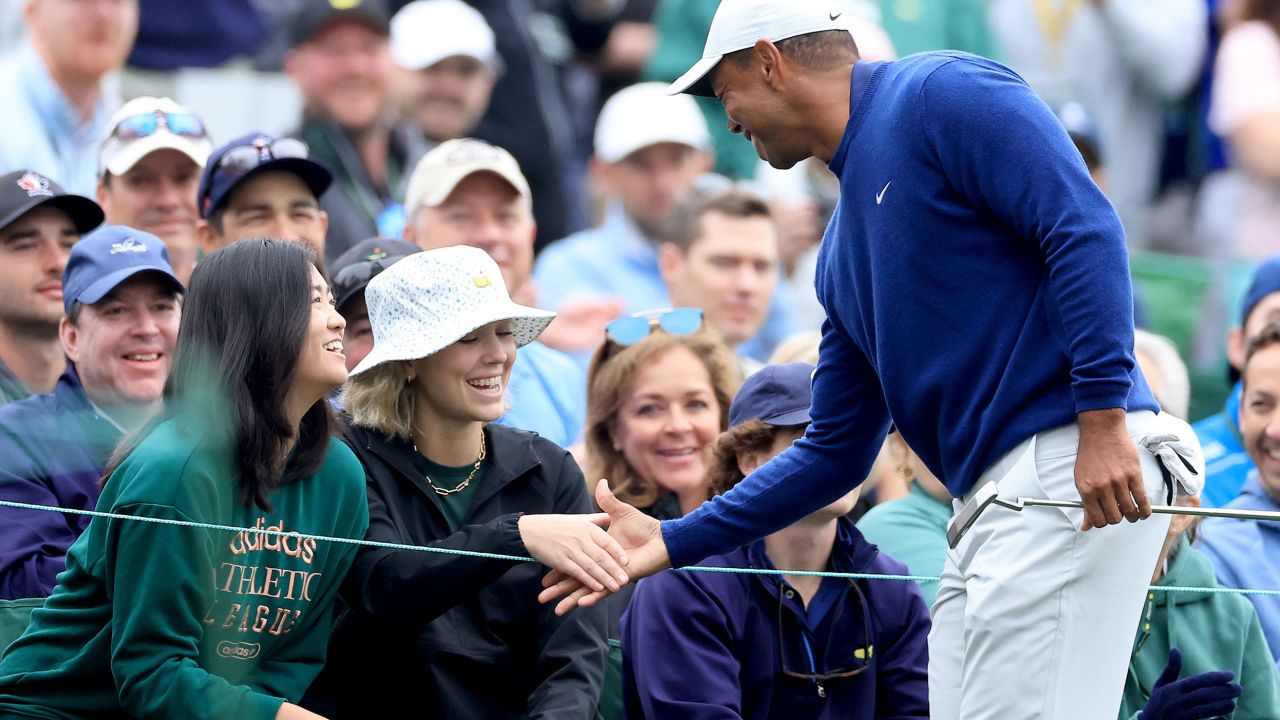 AUGUSTA, GEORGIA - APRIL 03: Tiger Woods of The United States says hello to Rose Zhang (front left green top) the winner of the Augusta National Women's Amateur and a friend behind the tee on the 12th hole during a practice round prior to the 2023 Masters Tournament at Augusta National Golf Club on April 03, 2023 in Augusta, Georgia. (Photo by David Cannon/Getty Images)