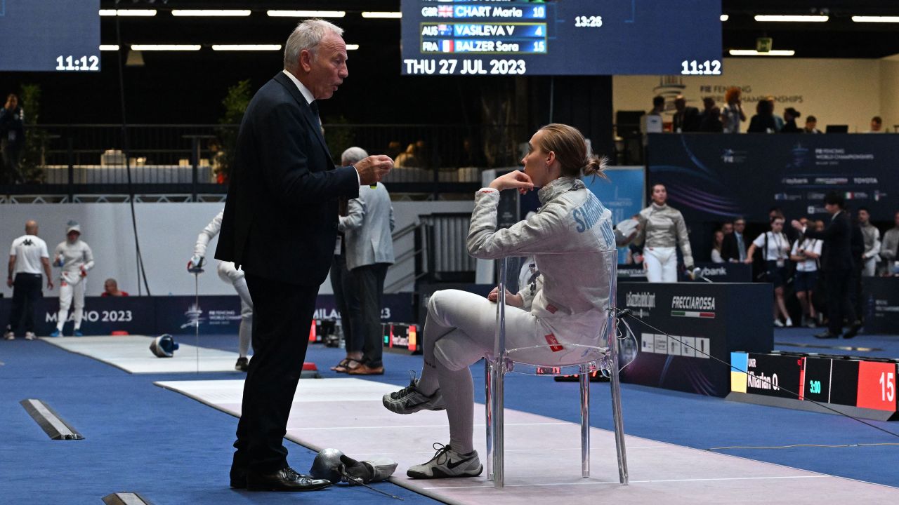 An official of the International Fencing Federation (FIE) speaks to Russia's Anna Smirnova, registered as an Individual Neutral Athlete (AIN), as she sits on the fencing strip after Ukraine's Olha Kharlan (not in picture), refused to shake hands with her, after Kharlan defeated her during the Sabre Women's Senior Individual qualifiers, as part of the FIE Fencing World Championships at the Fair Allianz MI.CO (Milano Convegni) in Milan, on July 27, 2023. (Photo by Andreas SOLARO / AFP) (Photo by ANDREAS SOLARO/AFP via Getty Images)