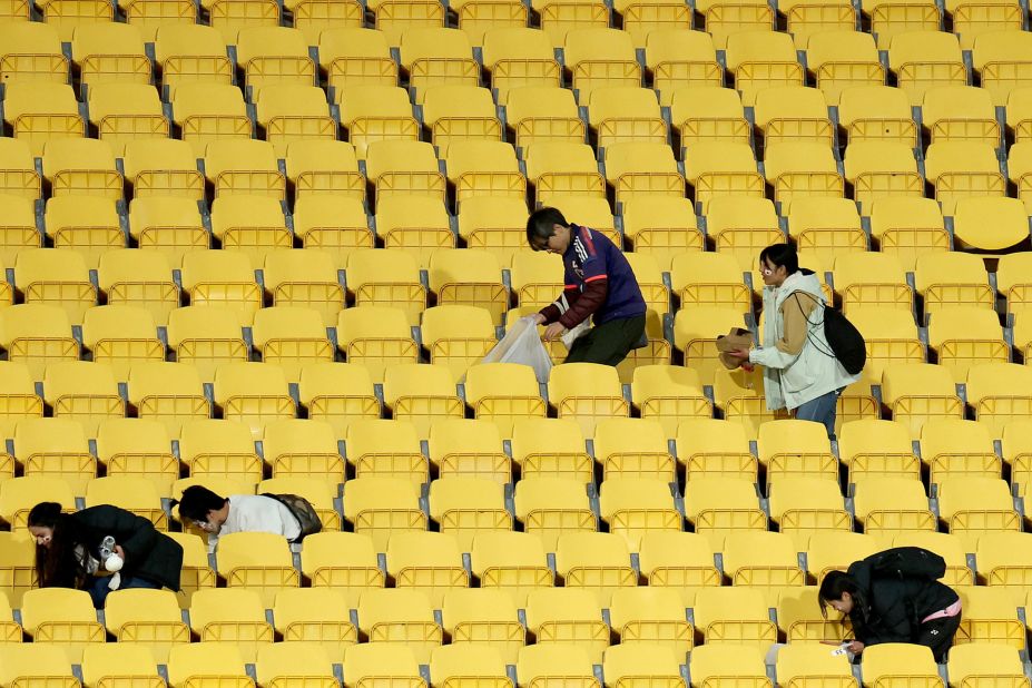 Fans of Japan help clean after the match in Wellington, New Zealand. Japan's fans have become known in recent years for their efforts to <a href="https://www.cnn.com/2023/07/22/football/japan-fans-tidying-womens-world-cup-2023-spt-intl/index.html" target="_blank">clean stands after matches</a>.