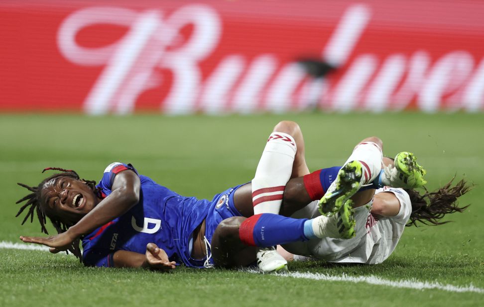 Haiti's Melchie Dumornay, left, gets tangled with Denmark's Simone Boye.