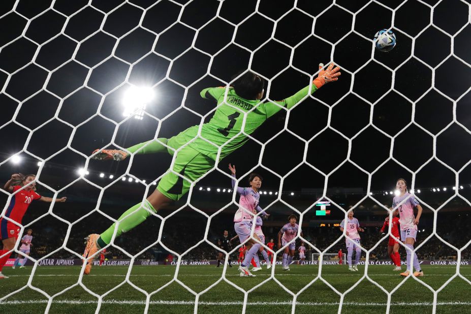 Ayaka Yamashita of Japan dives in vain as Guro Reiten of Norway (obscured) heads to score her team's first goal.