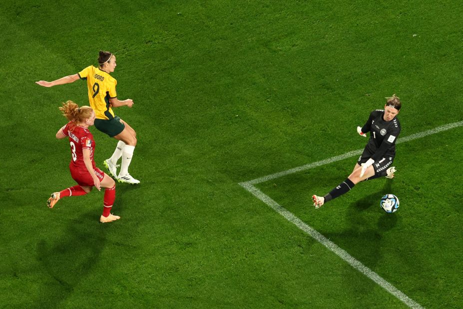 Australia's forward Caitlin Foord scores a goal past Denmark's goalkeeper Lene Christensen.