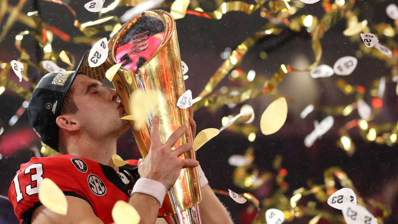 INGLEWOOD, CALIFORNIA - JANUARY 09: Stetson Bennett #13 of the Georgia Bulldogs celebrates by kissing the College Football Playoff National Championship Trophy after defeating the TCU Horned Frogs in the College Football Playoff National Championship game at SoFi Stadium on January 09, 2023 in Inglewood, California. Georgia defeated TCU 65-7. (Photo by Ezra Shaw/Getty Images)