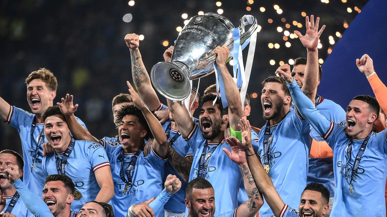 TOPSHOT - Manchester City's German midfielder #8 Ilkay Gundogan (C) lifts the European Cup trophy as they celebrate on the podium after winning the UEFA Champions League final football match between Inter Milan and Manchester City at the Ataturk Olympic Stadium in Istanbul, on June 10, 2023. (Photo by FRANCK FIFE / AFP) (Photo by FRANCK FIFE/AFP via Getty Images)