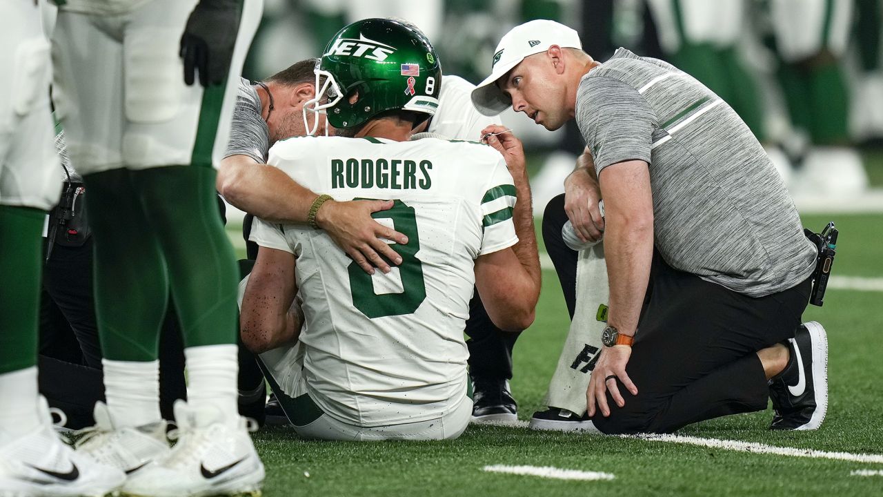 Rodgers being tended to on the field before he was taken off and missed the remainder of the game.