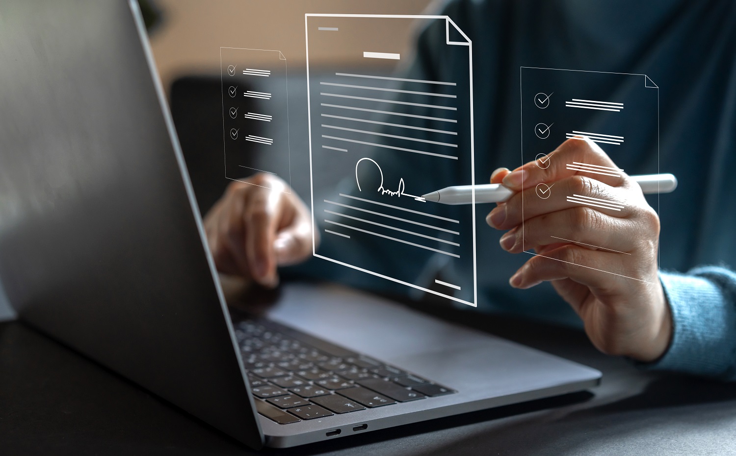 A person sitting in front of an open laptop computer signs a digital representation of a contract-like document with a stylus.