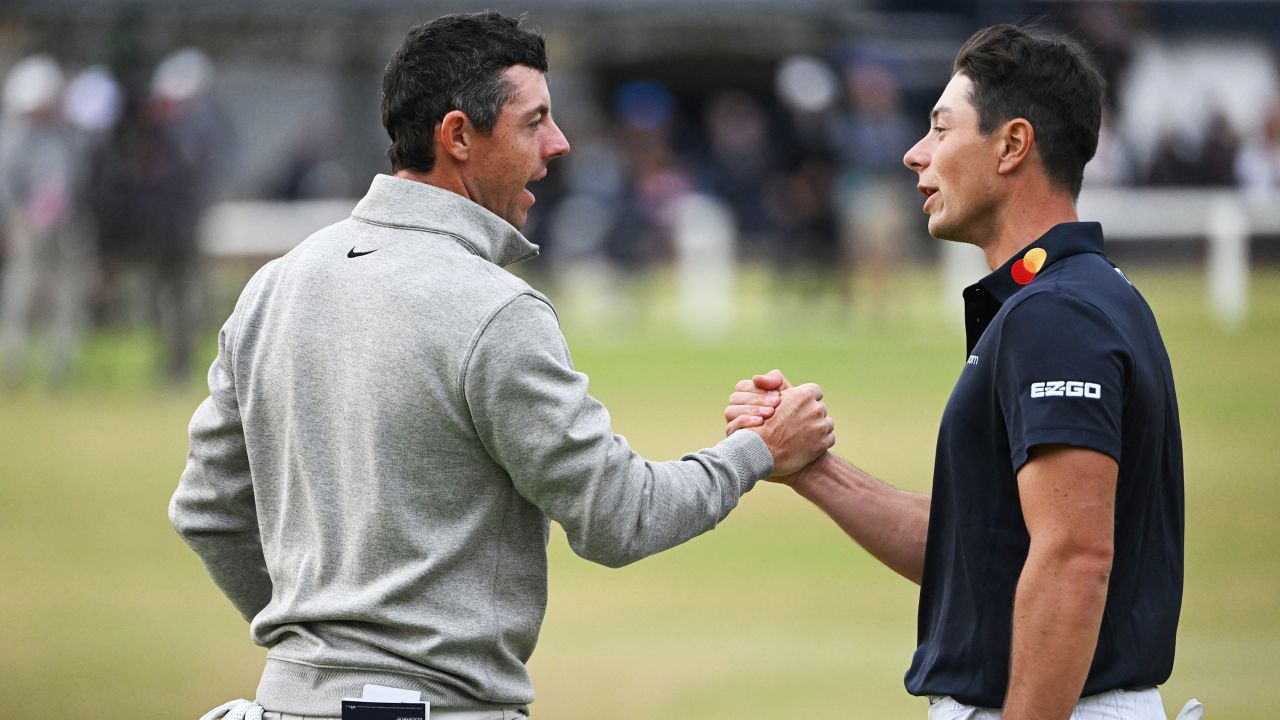 Norway's Viktor Hovland (R) and Northern Ireland's Rory McIlroy (L) shake hands on the 18th green after their third rounds on day 3 of The 150th British Open Golf Championship on The Old Course at St Andrews in Scotland on July 16, 2022.