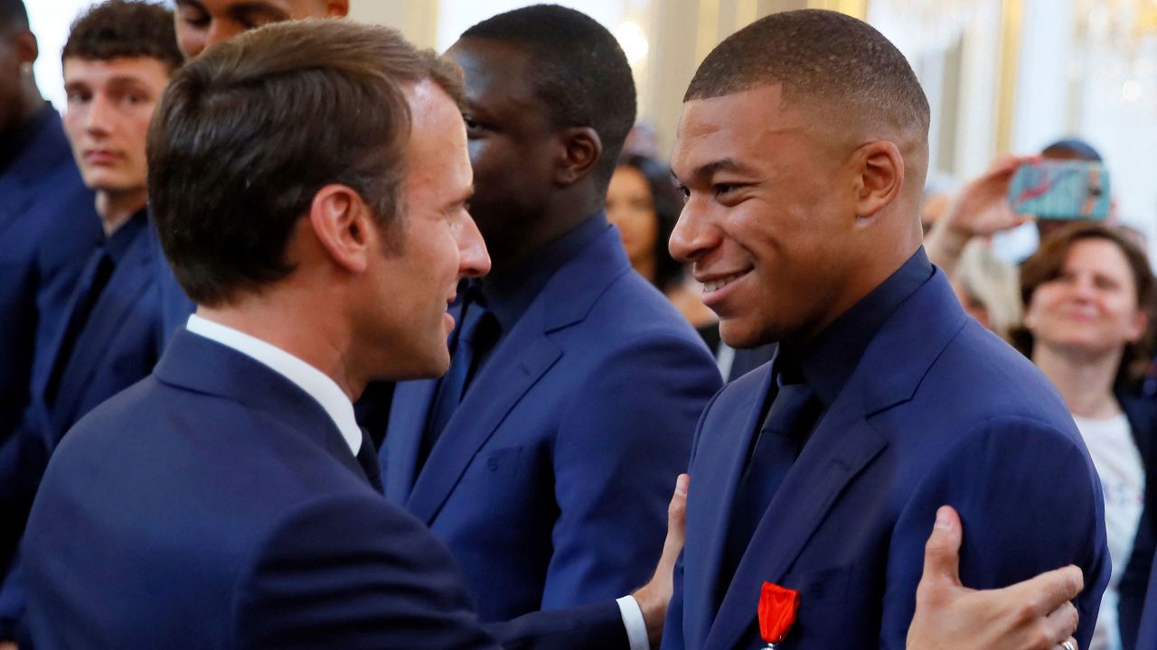 France's president Emmanuel Macron (L) embraces France's forward Kylian Mbappe (R) during a ceremony to award French 2018 football World Cup winners with the Legion of Honour at the Elysee Palace in Paris. - Kylian Mbappe made the startling revelation on May 23, 2022 that he had talked over his potential transfer to Real Madrid with Emmanuel Macron, saying he appreciated the "good advice" of the French President, who wanted the Paris Saint-Germain star to stay in France. (Photo by Francois Mori / POOL / AFP) (Photo by FRANCOIS MORI/POOL/AFP via Getty Images)