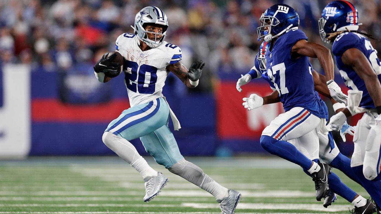 Dallas Cowboys' Tony Pollard, left, runs the ball during the second half of an NFL football game against the New York Giants, Sunday, Sept. 10, 2023, in East Rutherford, N.J.