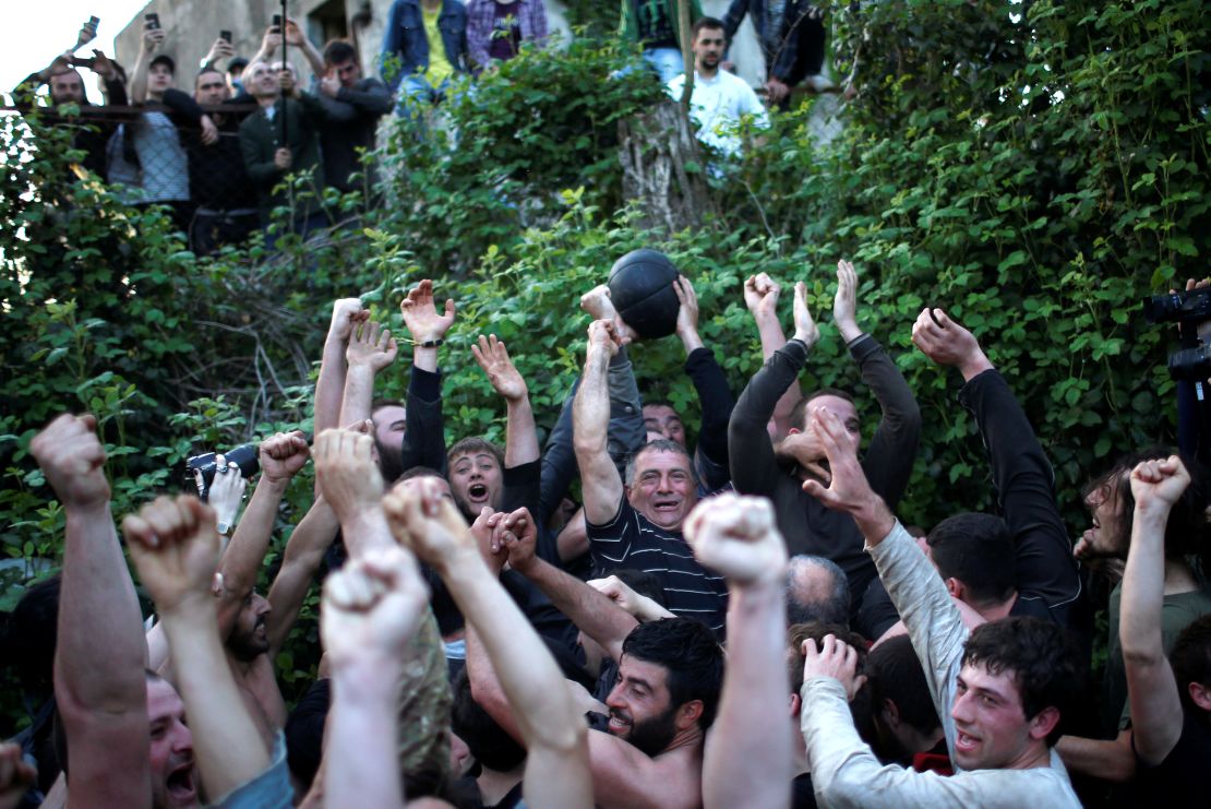 Winners celebrate as they cross the goal line during the annual Lelo match on Easter Sunday in the village of Shukhuti, Georgia, April 8, 2018.