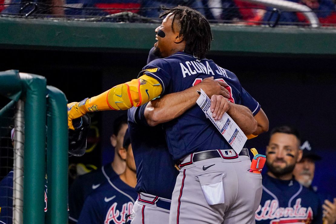 Atlanta Braves' Ronald Acuña Jr. gets a hug from the team's manager, Brian Snitker, after hitting a solo home run during a game against the Washington Nationals on Friday, Sept. 22.