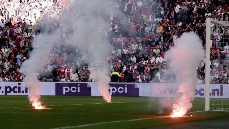 Police use tear gas to disperse fans outside stadium after Ajax match against Feyenoord abandoned