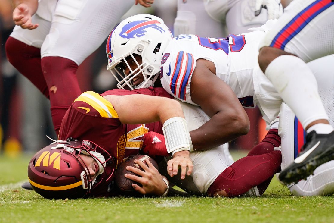 Washington Commanders quarterback Sam Howell (14) on the ground after being sacked by Buffalo Bills defensive end Greg Rousseau (50) during the second half of an NFL football game, Sunday, Sept. 24, 2023, in Landover, Md. (AP Photo/Evan Vucci)