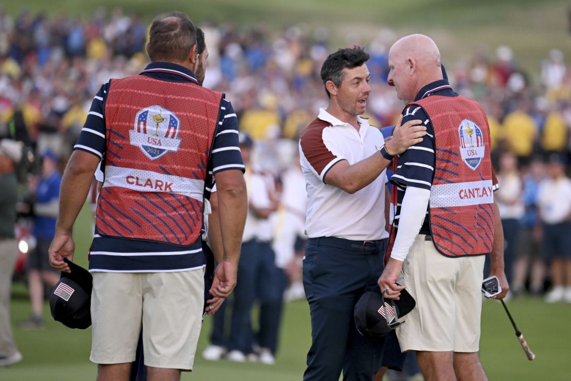 ROME, ITALY - SEPTEMBER 30: Rory McIlroy of Team Europe speaks with caddie of Patrick Cantlay of Team United States (not pictured), Joe LaCava on the 18th green during the Saturday afternoon fourball matches of the 2023 Ryder Cup at Marco Simone Golf Club on September 30, 2023 in Rome, Italy. (Photo by Ross Kinnaird/Getty Images)