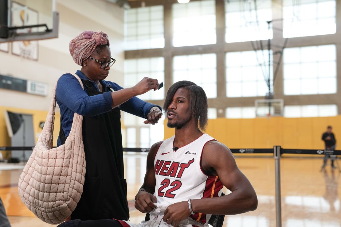 Miami Heat forward Jimmy Butler (22) gets his new hairdo brushed at the start of a TV interview, during the NBA basketball team's media day, in Miami, Monday, Oct. 2, 2023. (AP Photo/Rebecca Blackwell)