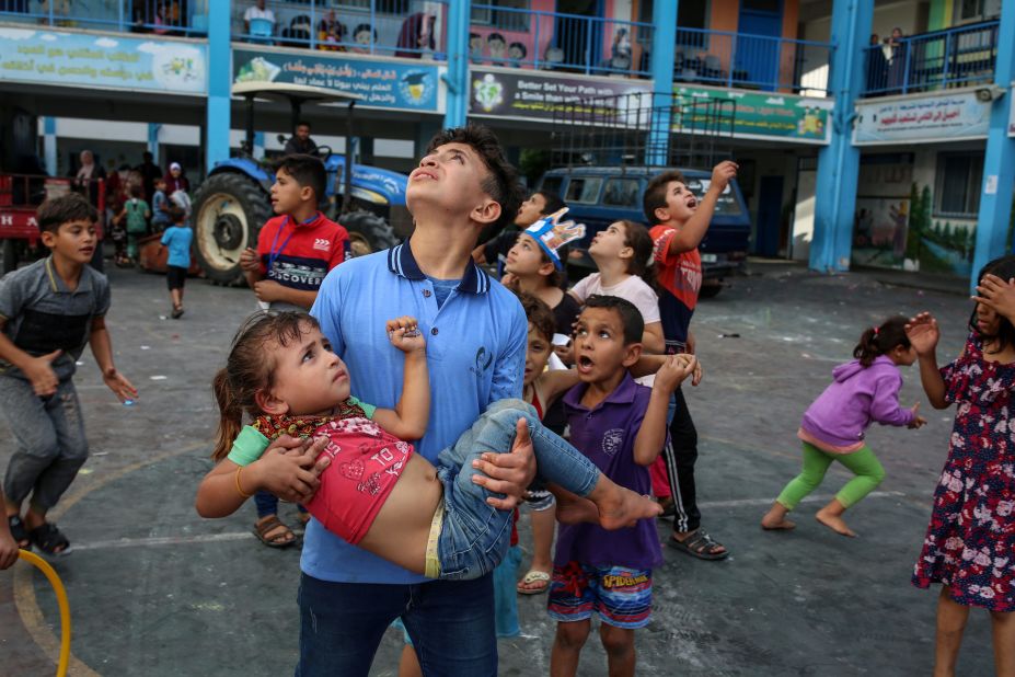 Palestinian children look toward the sky at the sound of airstrikes at a United Nations-run school in Gaza on Saturday, October 7.