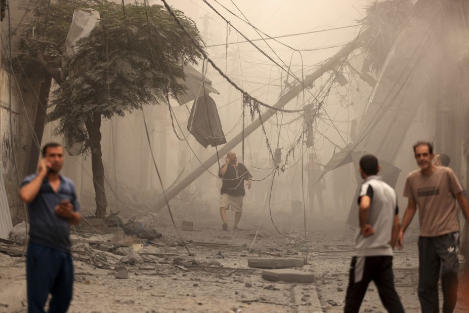 Palestinians inspect damage from Israeli airstrikes in Gaza City's Shati refugee camp on October 9.