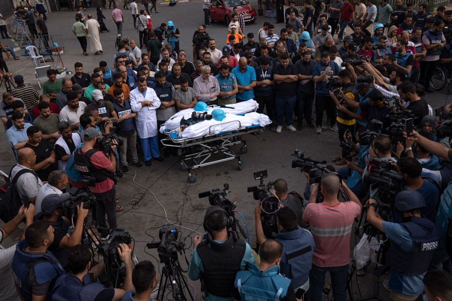 People gather around the bodies of two Palestinian reporters, Mohammed Soboh and Said al-Tawil, who were killed by an Israeli airstrike in Gaza City on October 10.