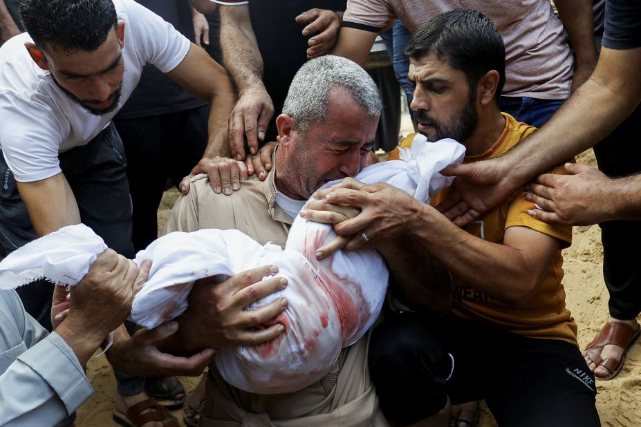 A mourner reacts while burying a child from the al-Agha family, who were killed in Israeli strikes in Khan Younis, Gaza, on October 11.